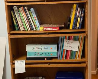 Wood book case with sliding glass doors, and various books.