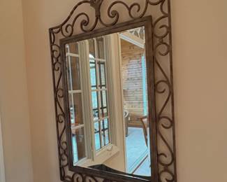 wrought iron wall mirror with ornate scrollwork