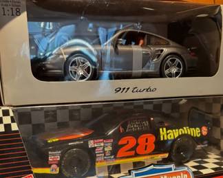 Porsche 911 Turbo sports car in its packaging and ERTL American Muscle 1:18 scale diecast model of the #28 Havoline Ford Thunderbird, driven by NASCAR driver Davey Allison.