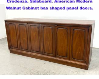 Lot 1252 MCM Mid Century BROYHILL Credenza. Sideboard. American Modern Walnut Cabinet has shaped panel doors.