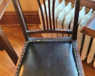 There are three of these unique leather-seated chairs.