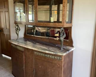 From another era -- check out this beautiful hutch with rounded glass upper cabinet, lower cabinet supported with brass birds and mirror back :)