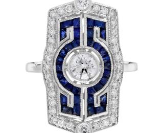 "This exquisite Art Deco inspired ring dazzles with its stunning combination of diamonds and blue sapphires, elegantly set in 14K white gold. The centerpiece is a captivating 0.30 carat round brilliant cut diamond, surrounded by a rich array of French cut blue sapphires that enhance its vintage charm. Accented by thirty-four smaller diamonds, this cocktail ring embodies both sophistication and opulence, making it a perfect statement piece for any elegant occasion. With a total weight of approximately 7.00 grams, this ring is as substantial as it is striking.

Victorins Auctions will coordinate all domestic and international shipping. Please allow approximately 10–15 business days for processing. Certain items may require additional handling time depending on their location, origin, or special packaging requirements. By registering for or placing a bid in a Victorins auction, you confirm that you have reviewed, understood, and agreed to our Shipping, Payment, and Auction Policies."
