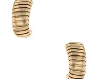 "This exquisite pair of Bulgari Tubogas gold earrings showcases a stunning vintage design from circa 1990. Crafted from luxurious 18k yellow gold, these earrings feature a ribbed pattern that adds depth and texture. Measuring 2.1 cm in length and 1 cm in width, each earring has a thickness of 1.2 cm and weighs 20.6 g, making them a substantial yet comfortable accessory for any occasion. Perfect for collectors and fashion enthusiasts alike, these non-pierced earrings embody timeless elegance and sophistication.

Victorins Auctions will coordinate all domestic and international shipping. Please allow approximately 10–15 business days for processing. Certain items may require additional handling time depending on their location, origin, or special packaging requirements. By registering for or placing a bid in a Victorins auction, you confirm that you have reviewed, understood, and agreed to our Shipping, Payment, and Auction Policies."
