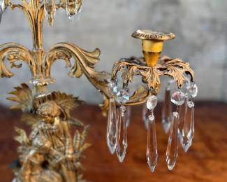 This lot features an antique, mid-19th century Victorian brass triple-light girandole candelabra with crystal prisms and a white marble base. This candelabra measures, 18” H x 15” W x 4” D. 
