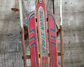 This lot features an antique “Silver Streak” sled that measures, 46” H x 22” W x 6” D.

