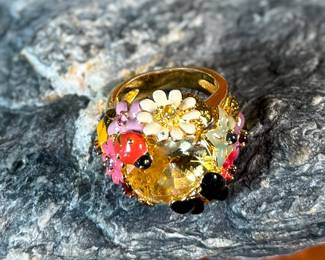 This lot features a reproduction of a ladybug floral enamel gold ring, originally made in 18k by Dior. This piece is believed to be a quality reproduction and is made of sterling silver. Marked 925 and comes in a size 8.
