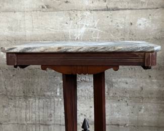 This lot features an antique Eastlake Victorian carved walnut parlor table with a marble top that measures, 28.5” H x 24” W x 16” D.
