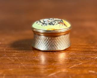 This lot features a porcelain figurine titled, "Cat and Mouse", manufactured by Lladro (model number 5236) & a cat themed trinket box manufactured by Bilston and Battersea. Bilston and Battersea enamels are fine English enamelware, originally produced in the 18th century and revived in the 20th century, known for decorative items like trinket boxes, pillboxes, and other luxury goods
