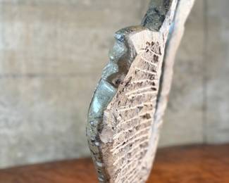 This lot features a stunning polished fossil sculpture featuring embedded ammonite and orthoceras fossils. This sculpture measures, 17.5” H x 12” W x 4” D.
