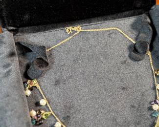 This lot features a stunning vintage 10k gold necklace with various stones including Amethyst, Peridot, Pearl, Blue Topaz, & Citrine, measuring 18” with a total approx. weight of 11.26 grams. Comes in a fancy presentation case and marked 10k as shown in photos.
