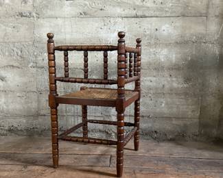 This lot features a Dutch bobbin corner chair with a rush seat, likely from the 1920s that measures, 29” H x 16” W x 16” D.

