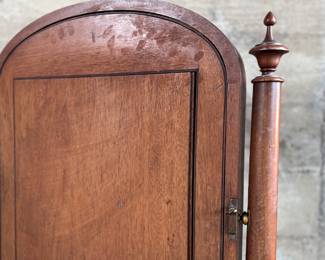 This lot features an antique American Empire gentleman’s shaving mirror with a tilt-top frame, fluted upright supports, and a shaped base with bun feet. This mirror measures, 33” H x 30” W x 12” D.
