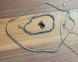This lot features a collection of sterling silver jewelry including bracelets, chains, and a pendant with a total approx. weight of 23.84 grams.
