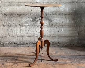 This lot features an early 19th-century Federal style New England cherry candlestand with a tripod spider leg base that measures, 28” H x 16.5” W x 16.5” D.
