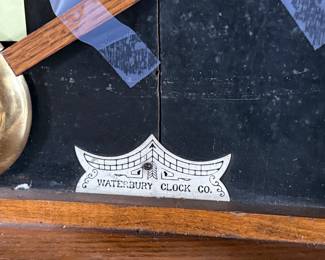 This lot features an antique clock made by the Waterbury Clock Company, with an advertising glass panel for Macdonald Jewelry Company. Appears complete with key, pendulum, instructions, and service records. This clock measures, 35” H x 16” W x 5” D. The Waterbury Clock Company factory is a historic complex of factory buildings in Waterbury, Connecticut. Development began in 1873, with the extensive plant serving as the company’s main manufacturing facility and headquarters until 1944.
