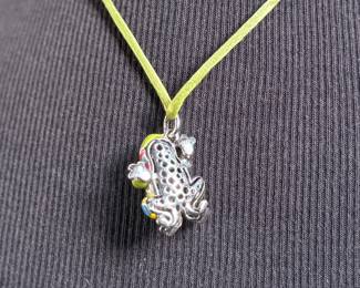 This lot features a Belle Étoile Lucky Frog pendant featuring hand-painted enameling in green, yellow, red, and blue. The pendant is made of sterling silver and marked 925 on the back as shown in photos. The pendant measures, 1.25” H x 1” W with a total approx. weight of 15.00 grams.
