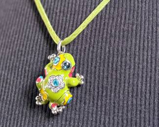This lot features a Belle Étoile Lucky Frog pendant featuring hand-painted enameling in green, yellow, red, and blue. The pendant is made of sterling silver and marked 925 on the back as shown in photos. The pendant measures, 1.25” H x 1” W with a total approx. weight of 15.00 grams.
