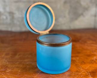 This lot features a vintage French blue opaline glass lidded keepsake box with brass trim that measures, 5” H x 4.75” W x 4.75” D. One small interior crack as shown in photos.
