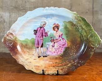This lot features an antique Limoges porcelain plate with a hand-painted scene. Marker mark underneath as shown in photos and measures, 13.25” H x 18.5” W. 
