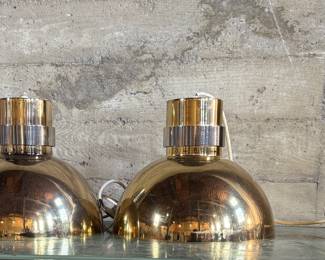 This lot features a pair of mid-century modern style brass pendant lights, manufactured by The Feldman Company, circa 1970s. Each one measures, 13” H x 16” W x 16” D.
