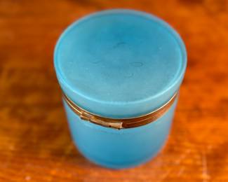 This lot features a vintage French blue opaline glass lidded keepsake box with brass trim that measures, 5” H x 4.75” W x 4.75” D. One small interior crack as shown in photos.
