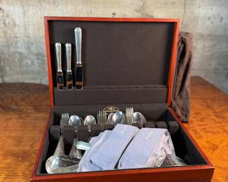 This lot features a stunning set of flatware by Christofle for Neiman Marcus. Each piece is beautifully marked as shown in photos, accompanied with Neiman Marcus covers, and housed in a vintage flatware box for safe storage. Christofle was founded in Paris in 1830 by Charles Christofle, who gained a reputation for his innovative silver plating technology and became a purveyor to the French court. The company grew significantly, supplying its flatware to royalty and even making its mark at international exhibitions, earning awards until at least 1937. Key moments in its history include acquiring the patents for electroplating in 1842, creating the America flatware collection in 1933, and introducing the Aria collection in 1985. 
This set includes two (2) large spoons, one (1) server, one (1) large fork, three (3) knives, twelve (12) big spoons, twelves (12) big forks, twelve (12) standard spoons, and eight (8) standard forks.