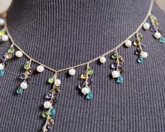 This lot features a stunning vintage 10k gold necklace with various stones including Amethyst, Peridot, Pearl, Blue Topaz, & Citrine, measuring 18” with a total approx. weight of 11.26 grams. Comes in a fancy presentation case and marked 10k as shown in photos.
