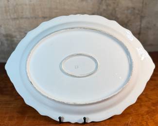 This lot features an antique Limoges porcelain plate with a hand-painted scene. Marker mark underneath as shown in photos and measures, 13.25” H x 18.5” W. 
