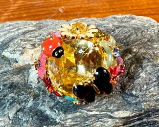 This lot features a reproduction of a ladybug floral enamel gold ring, originally made in 18k by Dior. This piece is believed to be a quality reproduction and is made of sterling silver. Marked 925 and comes in a size 8.
