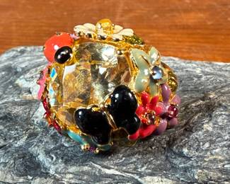 This lot features a reproduction of a ladybug floral enamel gold ring, originally made in 18k by Dior. This piece is believed to be a quality reproduction and is made of sterling silver. Marked 925 and comes in a size 8.
