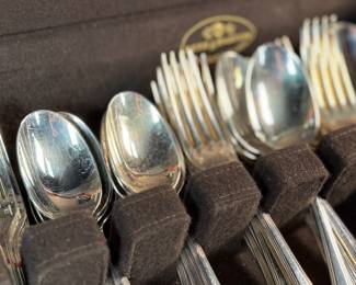 This lot features a stunning set of flatware by Christofle for Neiman Marcus. Each piece is beautifully marked as shown in photos, accompanied with Neiman Marcus covers, and housed in a vintage flatware box for safe storage. Christofle was founded in Paris in 1830 by Charles Christofle, who gained a reputation for his innovative silver plating technology and became a purveyor to the French court. The company grew significantly, supplying its flatware to royalty and even making its mark at international exhibitions, earning awards until at least 1937. Key moments in its history include acquiring the patents for electroplating in 1842, creating the America flatware collection in 1933, and introducing the Aria collection in 1985. 
This set includes two (2) large spoons, one (1) server, one (1) large fork, three (3) knives, twelve (12) big spoons, twelves (12) big forks, twelve (12) standard spoons, and eight (8) standard forks.