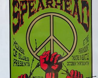 This lot features a concert poster for Michael Franti & Spearhead, designed and signed by artist, Justin Hampton. Limited edition, numbered 94/150 and measures, 25.5” H x 17.5” W. The concert was presented by the House of Blues and took place at the Paramount Theatre in Seattle. 
