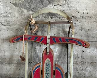 This lot features an antique “Silver Streak” sled that measures, 46” H x 22” W x 6” D.
