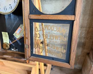 This lot features an antique clock made by the Waterbury Clock Company, with an advertising glass panel for Macdonald Jewelry Company. Appears complete with key, pendulum, instructions, and service records. This clock measures, 35” H x 16” W x 5” D. The Waterbury Clock Company factory is a historic complex of factory buildings in Waterbury, Connecticut. Development began in 1873, with the extensive plant serving as the company’s main manufacturing facility and headquarters until 1944.
