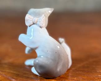 This lot features a porcelain figurine titled, "Cat and Mouse", manufactured by Lladro (model number 5236) & a cat themed trinket box manufactured by Bilston and Battersea. Bilston and Battersea enamels are fine English enamelware, originally produced in the 18th century and revived in the 20th century, known for decorative items like trinket boxes, pillboxes, and other luxury goods
