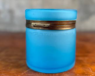 This lot features a vintage French blue opaline glass lidded keepsake box with brass trim that measures, 5” H x 4.75” W x 4.75” D. One small interior crack as shown in photos.
