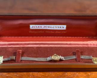 This is a vintage gold-tone Jules Jürgensen ladies’ dress watch with an integrated mesh bracelet, presented in its original box with 17 jewels and genuine diamonds. Winds and runs.
