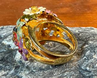 This lot features a reproduction of a ladybug floral enamel gold ring, originally made in 18k by Dior. This piece is believed to be a quality reproduction and is made of sterling silver. Marked 925 and comes in a size 8.
