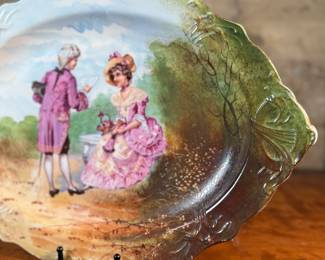 This lot features an antique Limoges porcelain plate with a hand-painted scene. Marker mark underneath as shown in photos and measures, 13.25” H x 18.5” W. 
