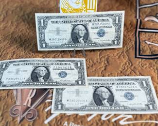 The Las Vegas lot! This lot features two coins featuring .999 fine silver, a bag of proof nickels, a new sealed card set, three (3) silver certificates, and a Baccarat table cover from The Hilton in Las Vegas.
