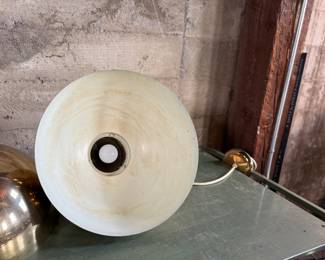 This lot features a pair of mid-century modern style brass pendant lights, manufactured by The Feldman Company, circa 1970s. Each one measures, 13” H x 16” W x 16” D.
