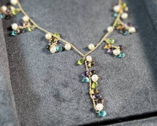 This lot features a stunning vintage 10k gold necklace with various stones including Amethyst, Peridot, Pearl, Blue Topaz, & Citrine, measuring 18” with a total approx. weight of 11.26 grams. Comes in a fancy presentation case and marked 10k as shown in photos.
