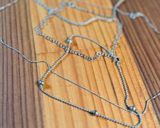 This lot features a collection of sterling silver jewelry including bracelets, chains, and a pendant with a total approx. weight of 23.84 grams.
