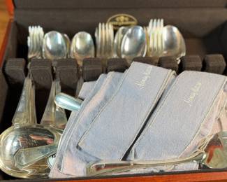 This lot features a stunning set of flatware by Christofle for Neiman Marcus. Each piece is beautifully marked as shown in photos, accompanied with Neiman Marcus covers, and housed in a vintage flatware box for safe storage. Christofle was founded in Paris in 1830 by Charles Christofle, who gained a reputation for his innovative silver plating technology and became a purveyor to the French court. The company grew significantly, supplying its flatware to royalty and even making its mark at international exhibitions, earning awards until at least 1937. Key moments in its history include acquiring the patents for electroplating in 1842, creating the America flatware collection in 1933, and introducing the Aria collection in 1985. 
This set includes two (2) large spoons, one (1) server, one (1) large fork, three (3) knives, twelve (12) big spoons, twelves (12) big forks, twelve (12) standard spoons, and eight (8) standard forks.