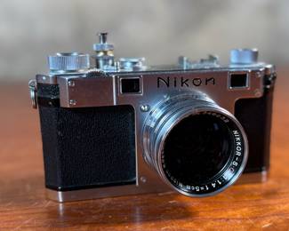 The lot features a vintage Nikon S rangefinder camera with a Nikkor-S 5cm f/1.4 lens. The Nikon S was the first Nikon camera to be imported to the US market. Tested and in good working condition.
