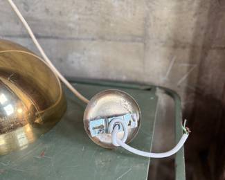 This lot features a pair of mid-century modern style brass pendant lights, manufactured by The Feldman Company, circa 1970s. Each one measures, 13” H x 16” W x 16” D.
