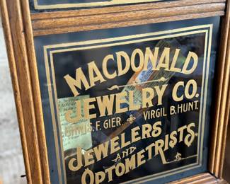 This lot features an antique clock made by the Waterbury Clock Company, with an advertising glass panel for Macdonald Jewelry Company. Appears complete with key, pendulum, instructions, and service records. This clock measures, 35” H x 16” W x 5” D. The Waterbury Clock Company factory is a historic complex of factory buildings in Waterbury, Connecticut. Development began in 1873, with the extensive plant serving as the company’s main manufacturing facility and headquarters until 1944.
