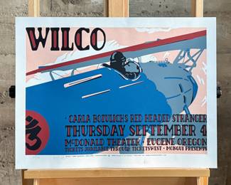 This lot features a rare signed and numbered silkscreen print from Wilco’s 2003 McDonald Theater performance with Carla Bozulich’s Red Headed Stranger. Numbered 102/165 and signed in pencil by artist, Gary Houston. This print measures, 18” H x 24” W.
