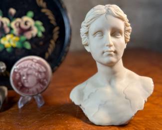 This lot features a collection of antiques and collectibles including sculpture, brass candlesticks, a Zwaro pottery vase, and more.
